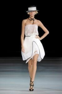 Юбка тюльпан белого цвета с подчёркнутым разрезом от Emporio Armani 2012 с полупрозрачным белым топом Emporio Armani и чёрного цвета босоножками на высоком каблуке Emporio Armani 