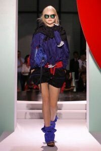 Мини юбка тюльпан чёрного цвета с карманами от Kenzo 2012 с мягким жакетом насыщенно фиолетового цвета Kenzo и ботильонами сине-фиолетового цвета с открытым носком Kenzo 