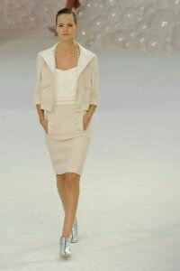 Укороченная юбка-карандаш бежевого цвета с карманами от Chanel 2012 с молочного цвета топом на бретелях и укороченным пиджаком в тон юбке Chanel и серебристого цвета ботильонах на каблуке Chanel