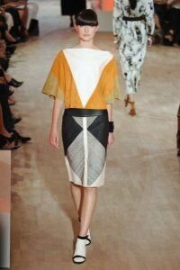 Юбка-карандаш с графическим принтом серо-чёрных тонов от Hermes 2012 со свободной блузкой бело-песочных тонов Hermes и закрытыми туфлями бело-чёрных тонов на невысоком каблуке Hermes