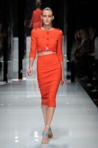 Юбка-карандаш красно-морковного цвета с завышенной талией от Versace 2011 с укороченным жакетом красно-морковного цвета Versace и босоножками бежево-голубого цвета на каблуке Versace